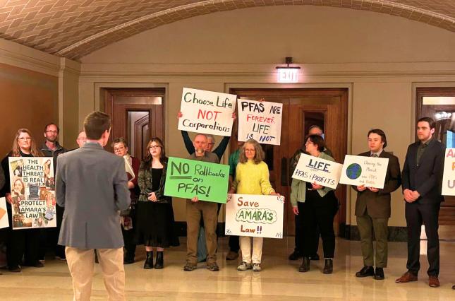 Rally in the MN State Capitol building with signs like "Save Amara's Law" and "No Rollbacks on PFAS!"