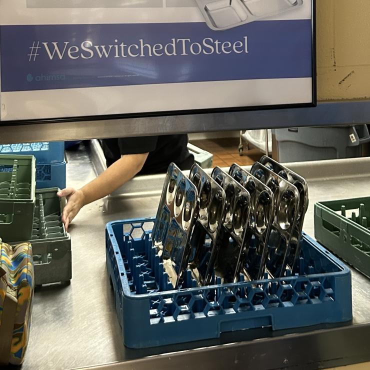 A rack of steel lunch trays lined up for washing
