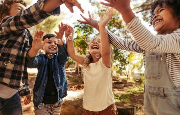 Image of kids happy and blowing bubbles. Canva image.