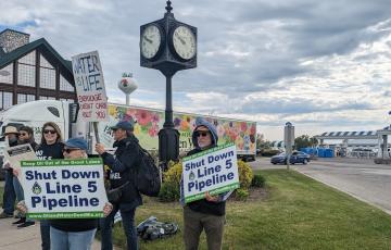 Protestors in Mackinaw City holding "Shut Down Line 5 Pipeline" signs