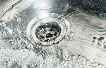 Water flowing into a drain. Photo credit: Jitinatt Jufask / Shutterstock