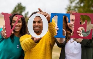 People hold letters that spell vote.