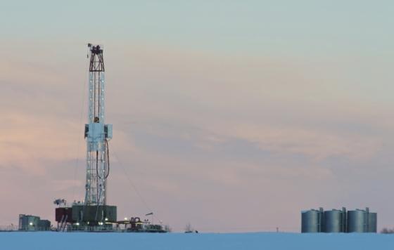 Picture of a drilling rig on a snowy landscape at dawn