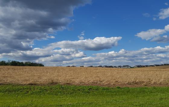 A new development peeks from behind farm fields
