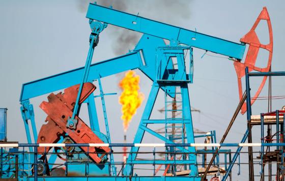 Pumpjacks with a methane flare in the background. Photo credit: Leonid Ikan / Shutterstock
